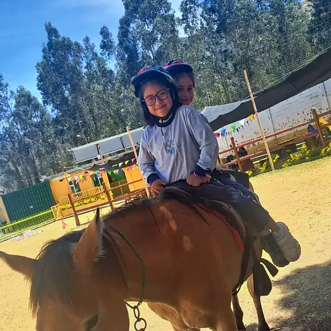 Dos niñas con casco montan juntas a Dorita, la yegua de hipoterapia.